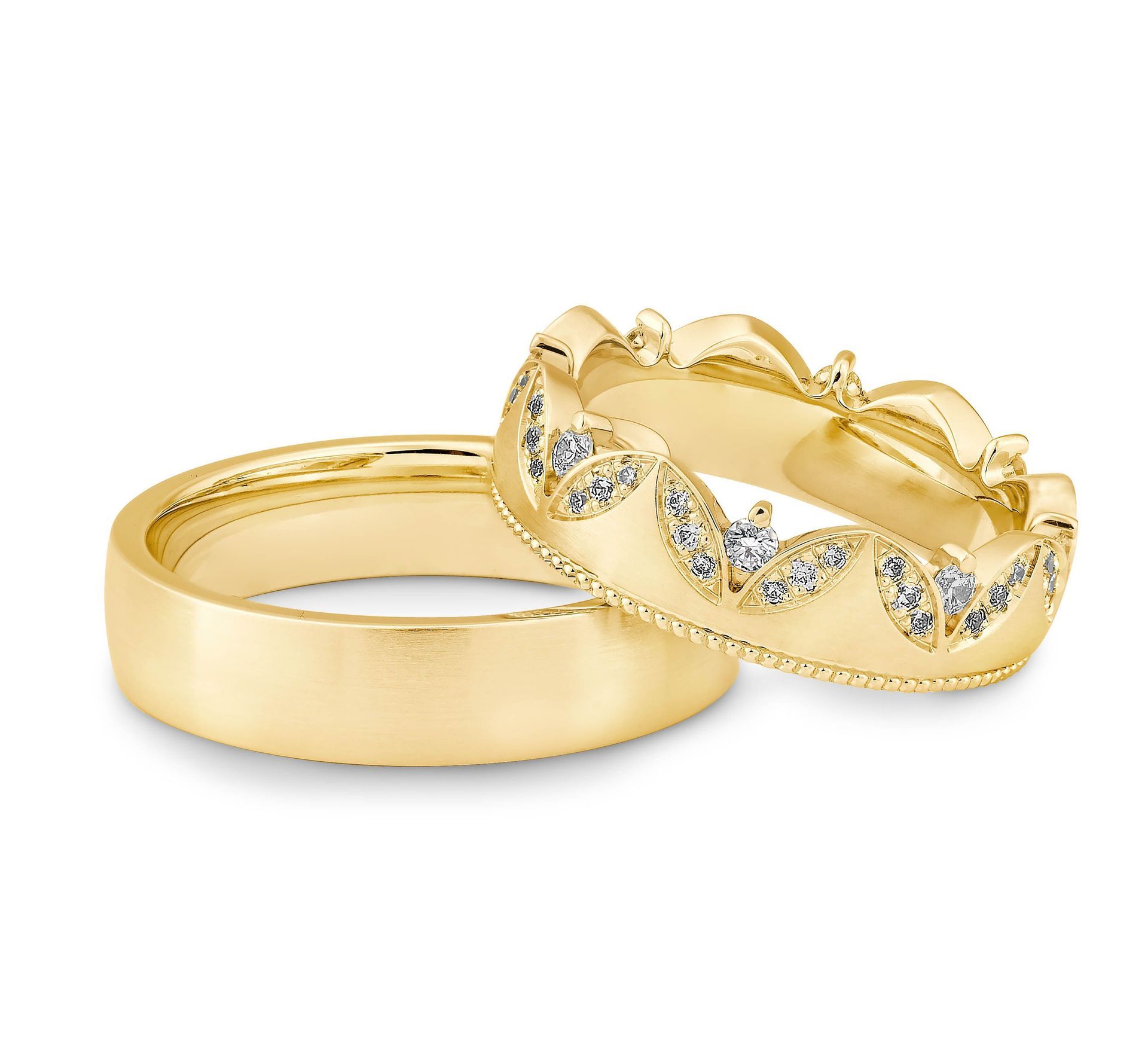 Twee gouden trouwringen, één eenvoudig en de andere met diamanten en een bladmotief.