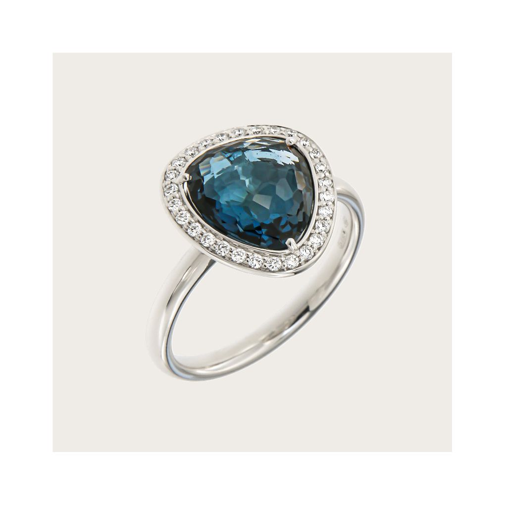 Zilveren ring met een driehoekige, donkerblauwe edelsteen, omringd door kleine diamantjes.