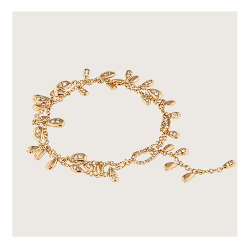 Gouden armband met bladvormige bedels en kleine kristallen, op een lichte achtergrond.