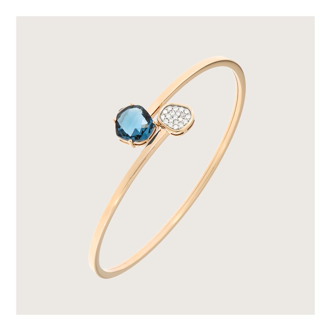 Gouden armband met een blauwe edelsteen en een cluster witte stenen.
