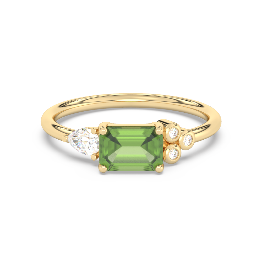 Gouden ring met een groene smaragd geslepen middelste steen, een peervormige zijsteen en twee kleine ronde zijstenen.