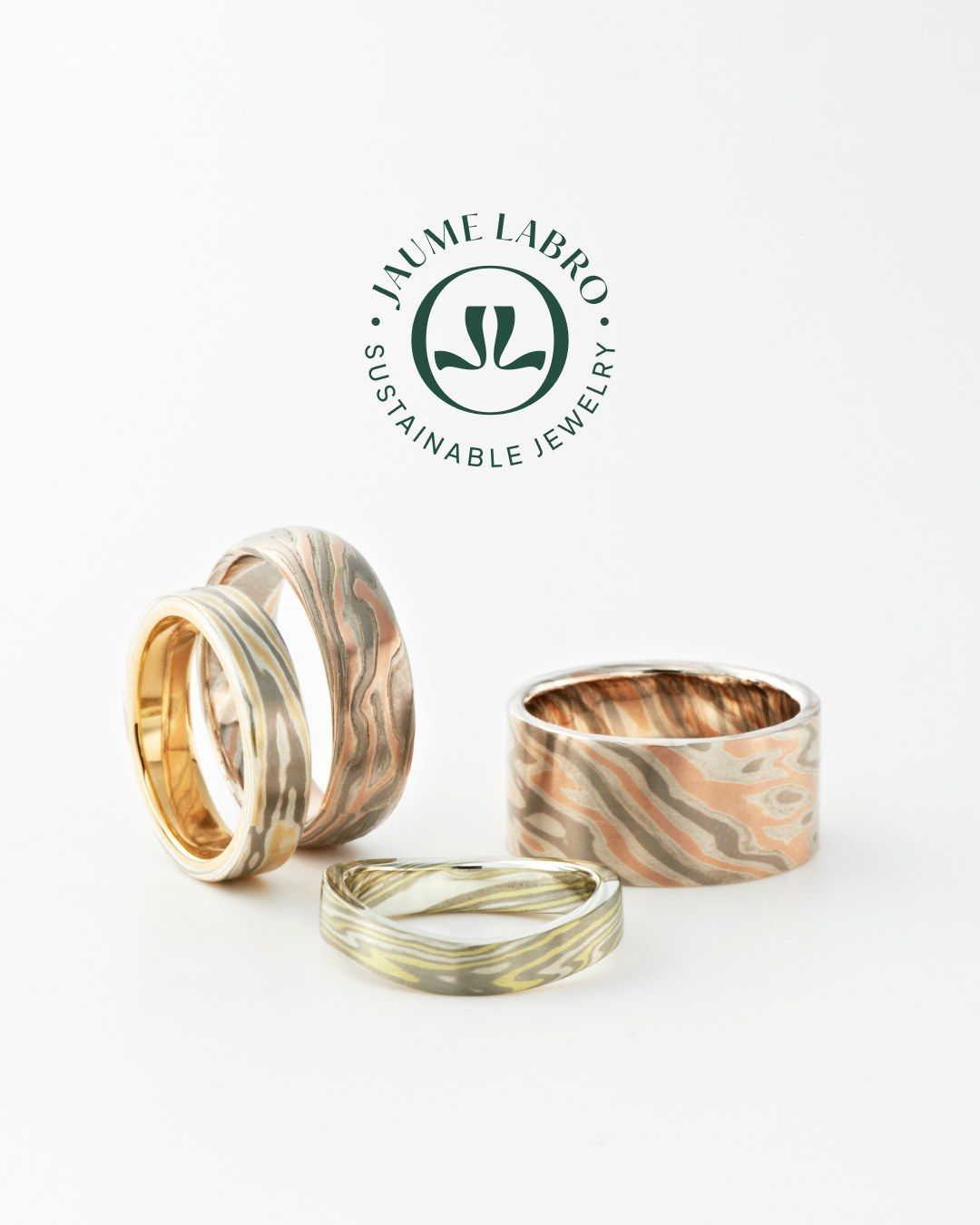 Vier unieke ringen op een witte achtergrond, met logo bovenaan. De ringen zijn voorzien van een getextureerd ontwerp met gemengde metalen.