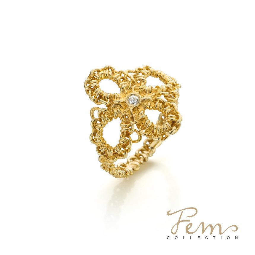 Gouden ring in de vorm van een bloem met een klein diamantje in het midden, op een witte achtergrond.