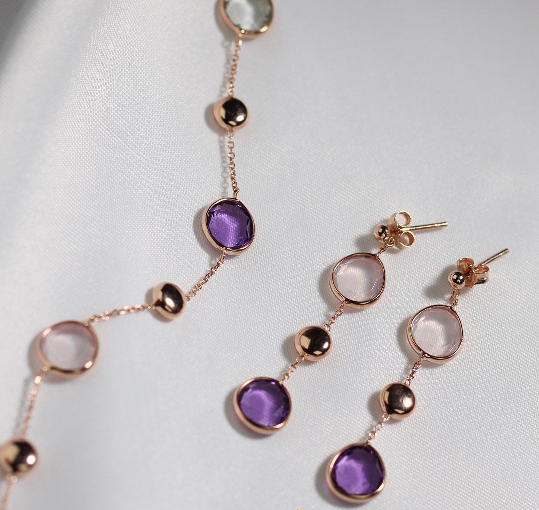 Gouden sieraden bezet met ronde amethist en rozenkwarts stenen.