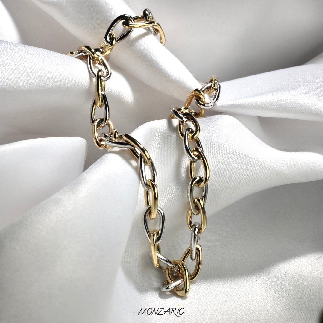 Armband van goud en zilver op witte satijnen stof.