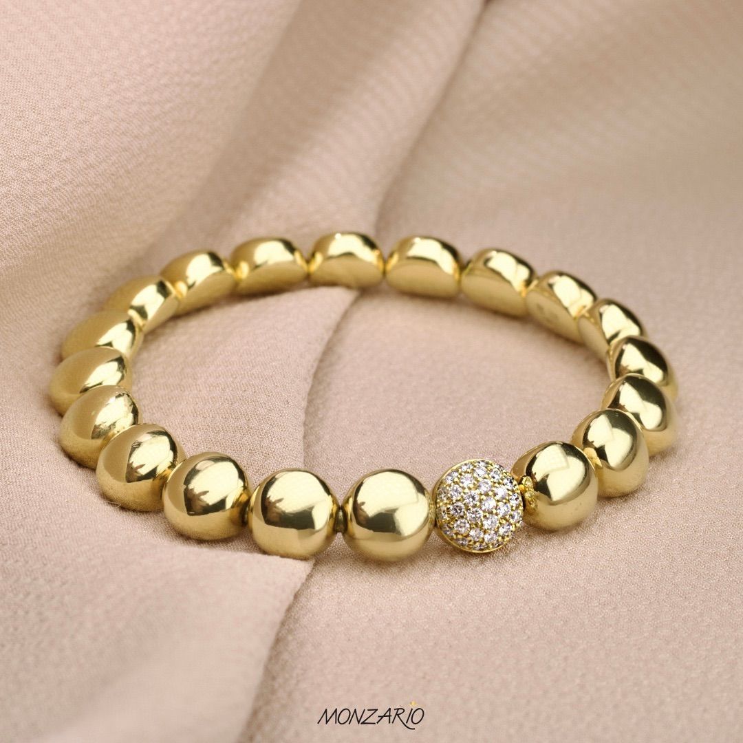 Armband van gouden kralen met één glinsterende strass-steen.