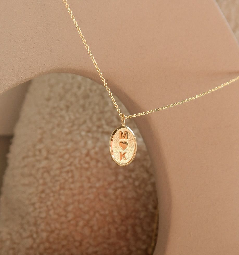 Gouden ketting met een ovale hanger met de initialen 