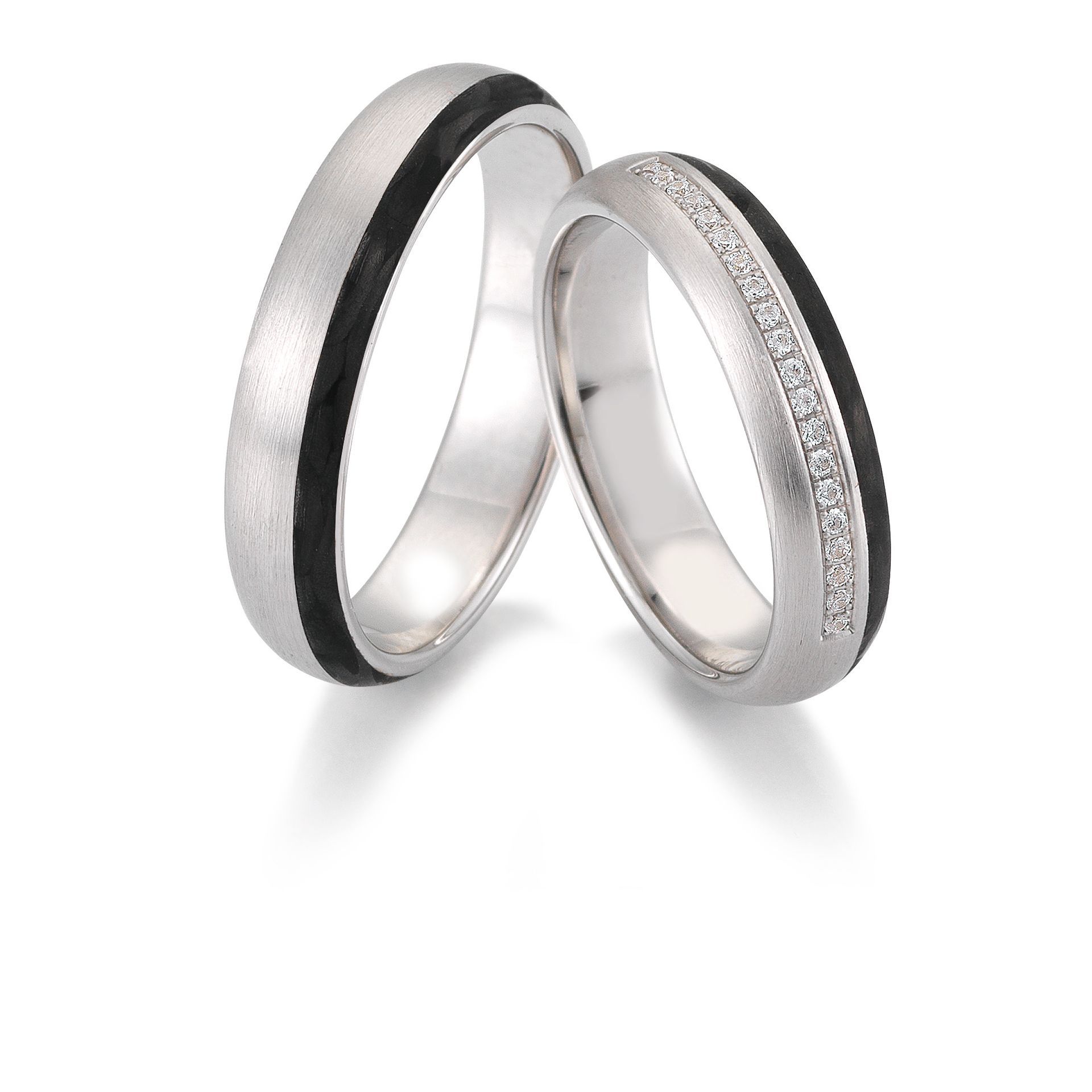 Twee zilveren trouwringen met zwarte inleg; één met diamanten.