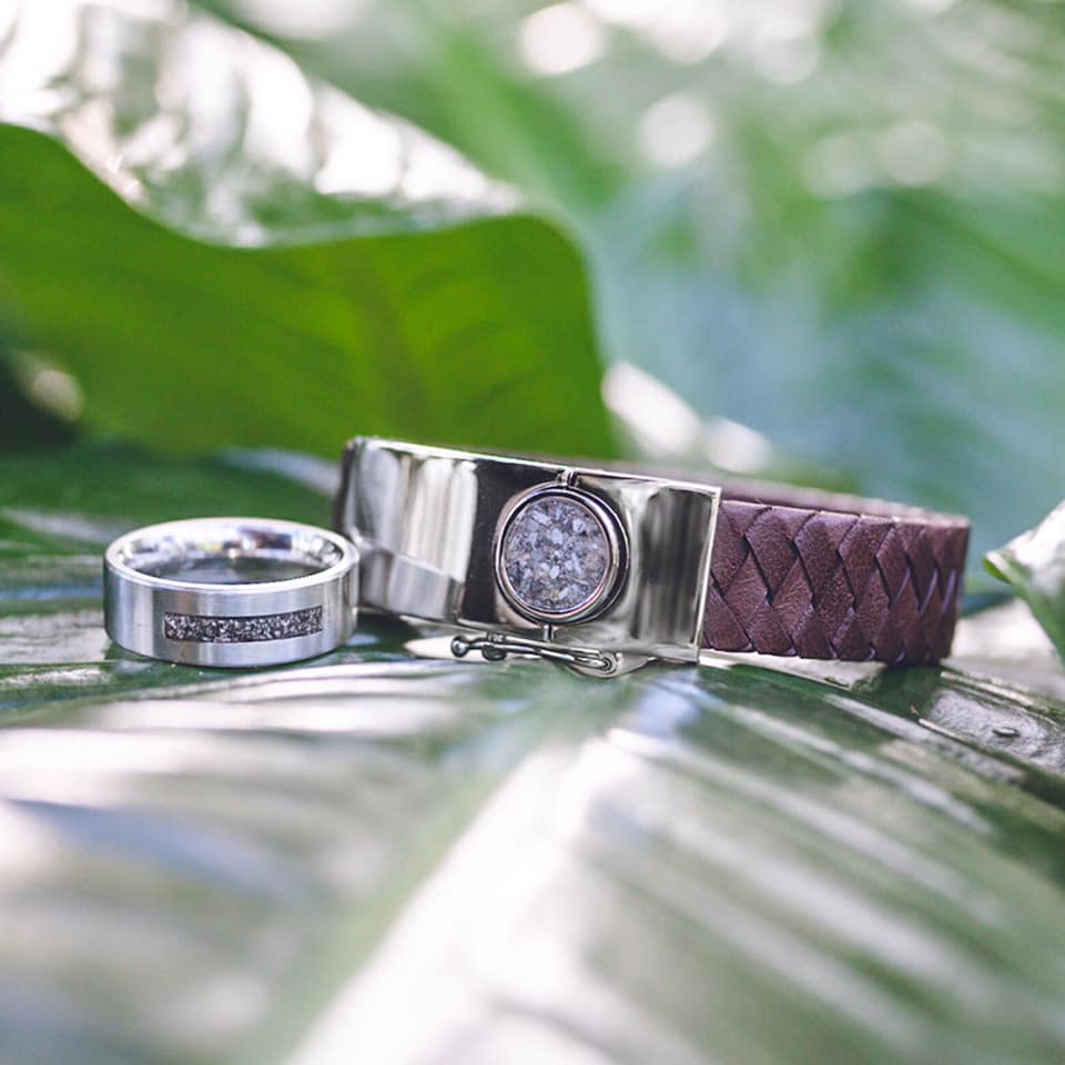 Zilveren ring en armband op een groen blad. Op de ring staat