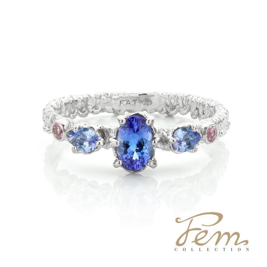 Zilveren ring met een blauwe ovale edelsteen en omringende blauwe en roze edelstenen.