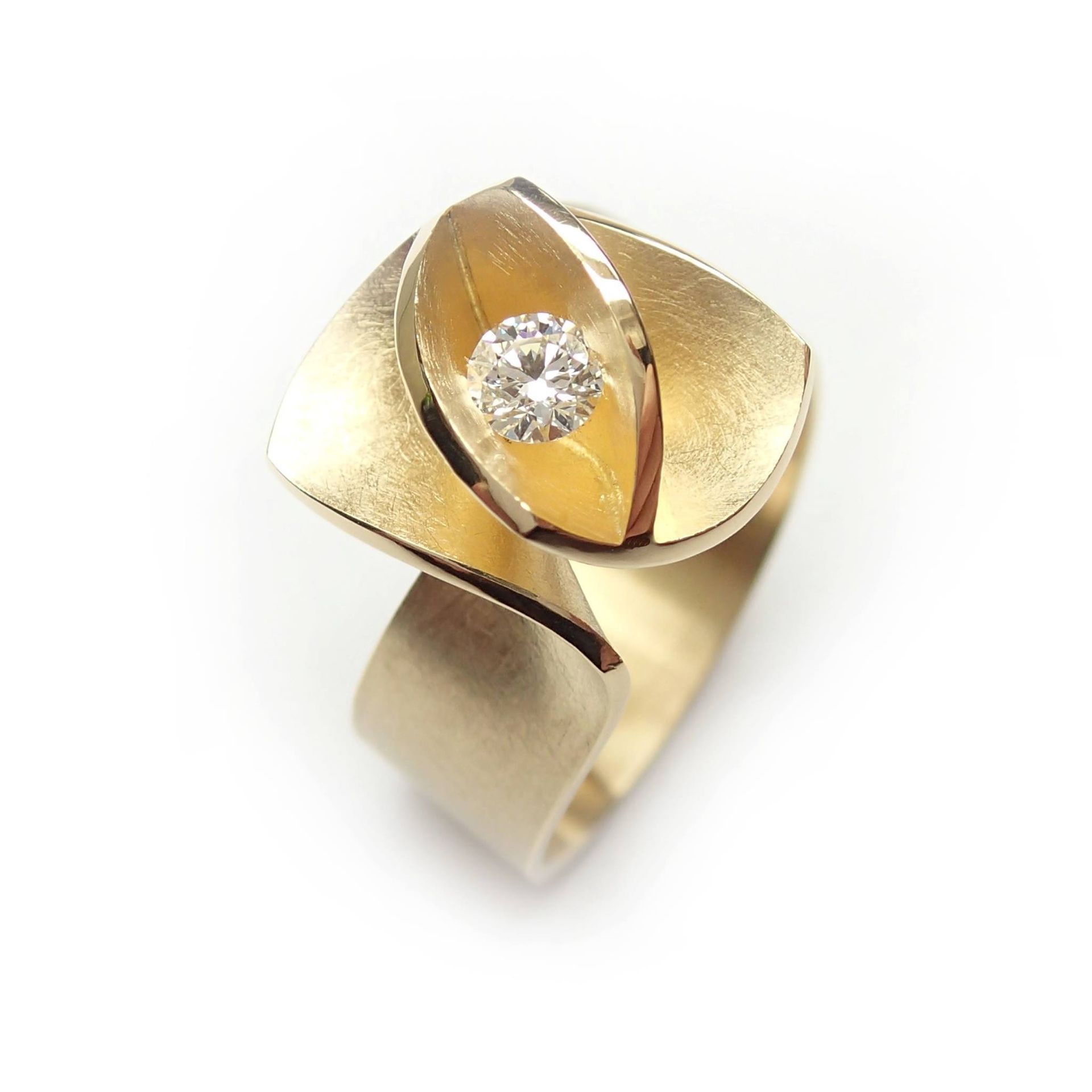 Gouden ring met een centrale diamant, gezet in een bladvormig ontwerp.