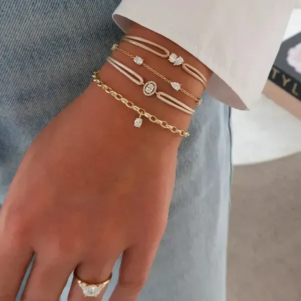 Vrouw draagt ​​gouden oorringen, steker, ketting en ring; close-up.