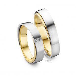 Tweekleurige trouwringen: zilveren buitenband, gouden binnenband. Eén ring heeft drie kleine diamanten.
