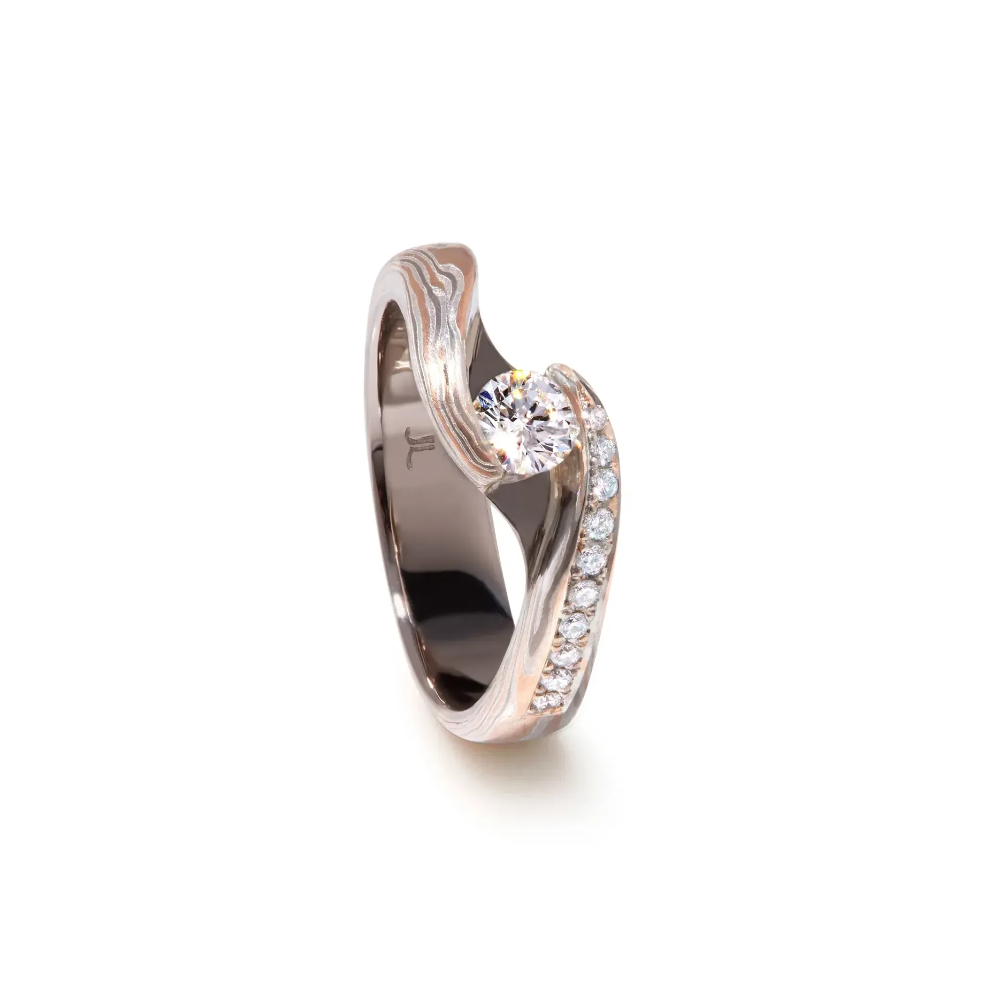 Verlovingsring met diamant, bestaande uit een wervelende, gestructureerde band bezet met kleine diamanten.