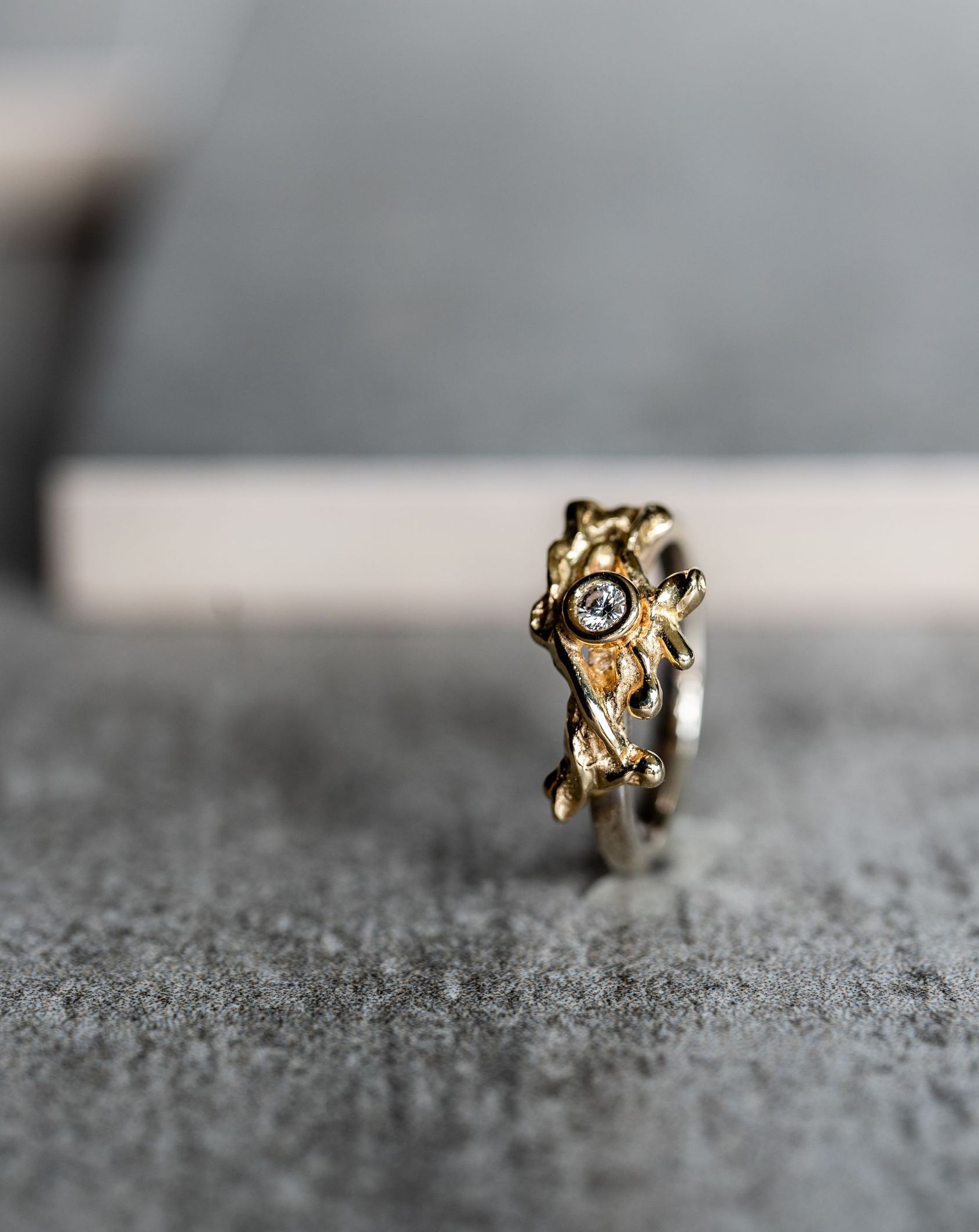 Gouden ring met structuurmotief en een klein diamantje.