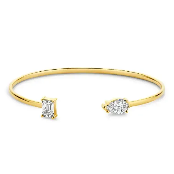 Gouden ringen met diamanten op een reflecterend koperen oppervlak.