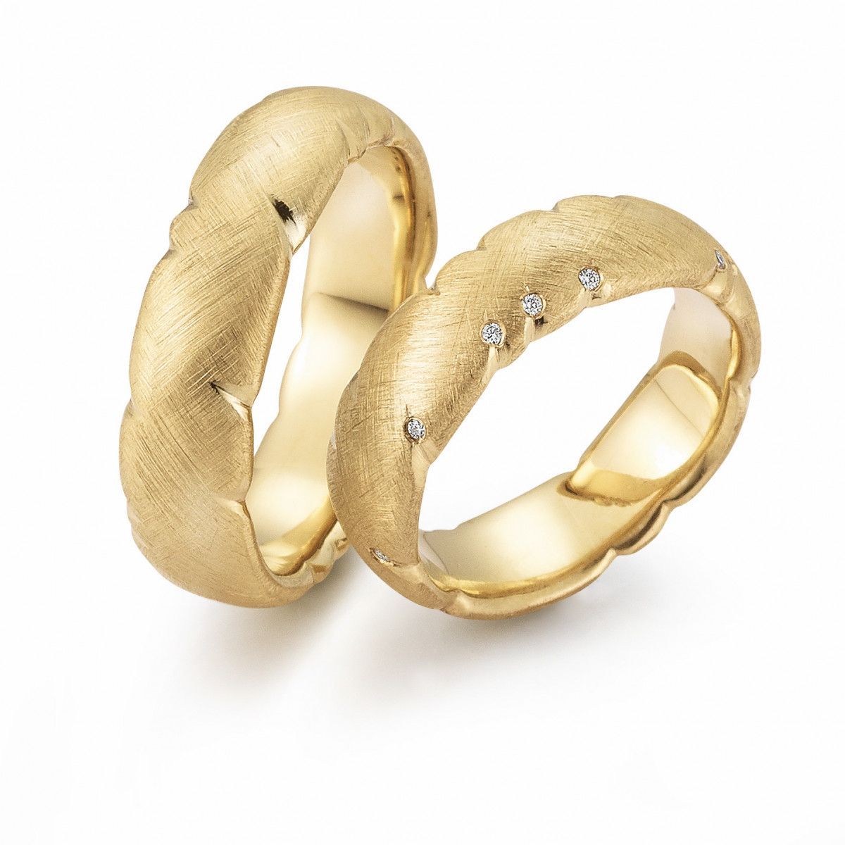 Twee gouden trouwringen, waarvan één met diamanten, op een witte achtergrond.