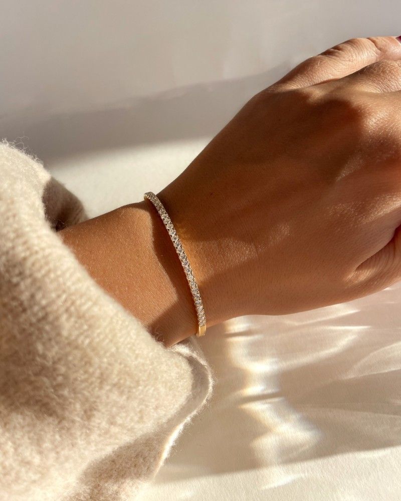 Gouden ringen met diamanten op een reflecterend koperen oppervlak.