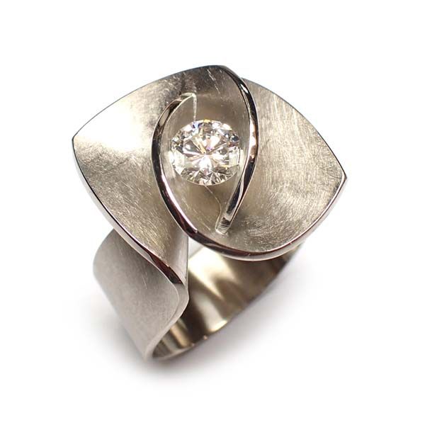 Diamanten ring met een uniek, wervelend ontwerp; zilverkleurig metaal met een geborstelde textuur.