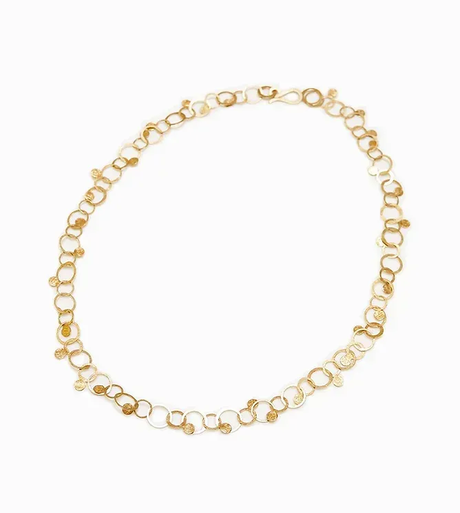 Goudkleurige, delicate ketting met verbonden cirkels en kleine hangende details, tegen een witte achtergrond.