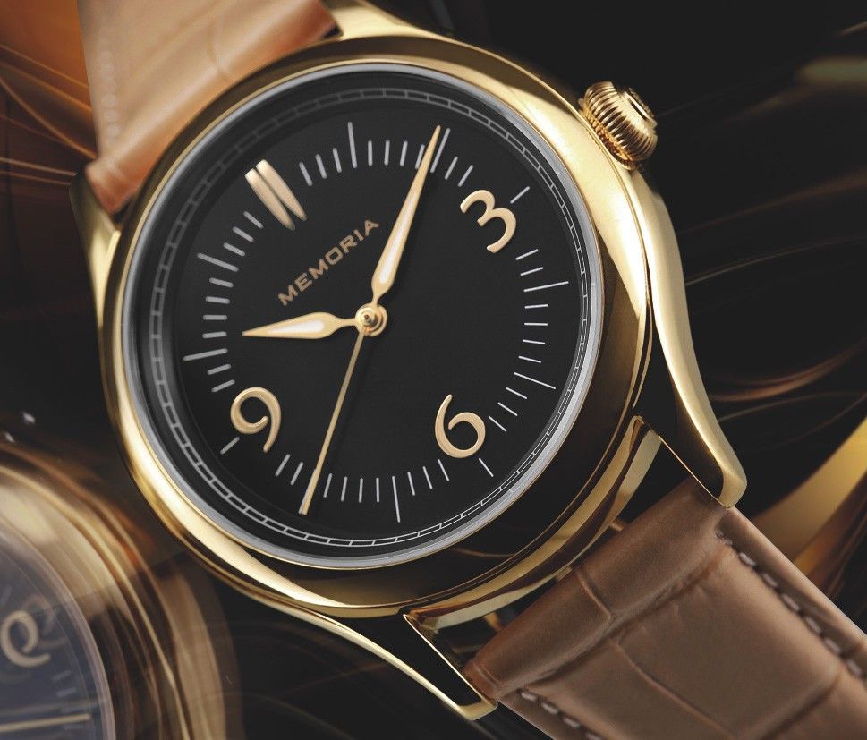 Gouden horloge met zwarte wijzerplaat, gouden cijfers en wijzers, bruine leren band.