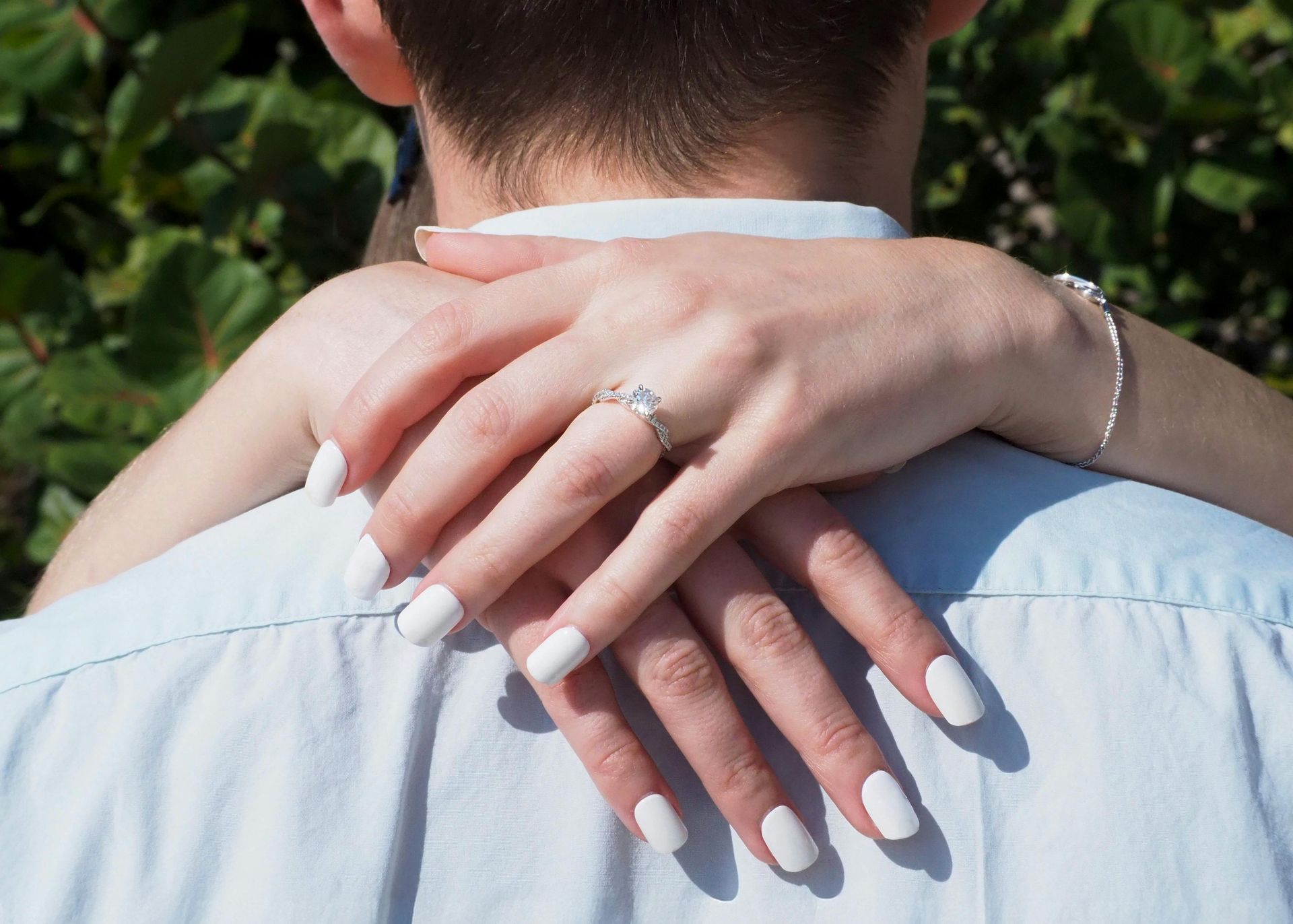 De bruidegom schuift een trouwring om de vinger van zijn bruid tijdens de ceremonie. Perzikkleurige stropdas, grijs pak.