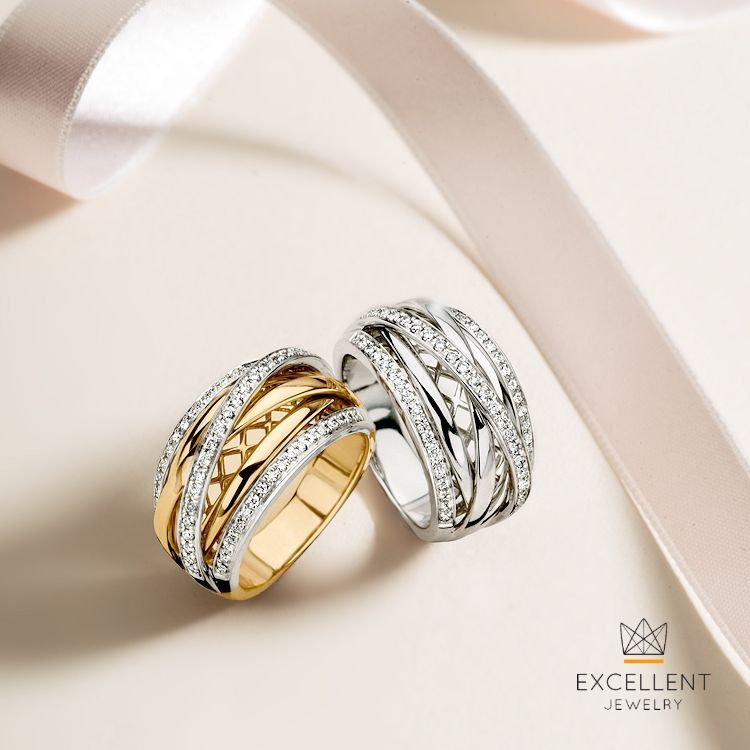 Twee ringen, bezet met diamanten, één van goud en één van zilver, op een lichte achtergrond met lint.