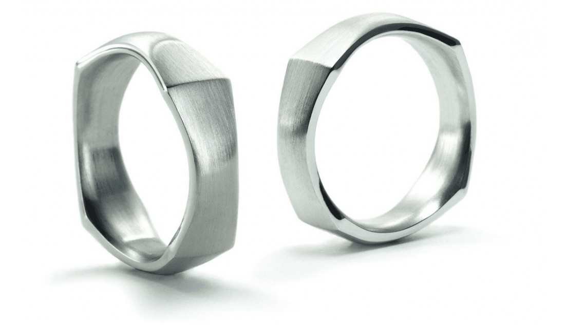 Twee zilveren ringen met geometrische, gefacetteerde ontwerpen.