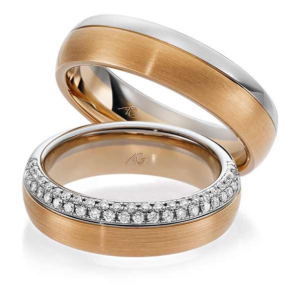 De bruidegom schuift een trouwring om de vinger van zijn bruid tijdens de ceremonie. Perzikkleurige stropdas, grijs pak.