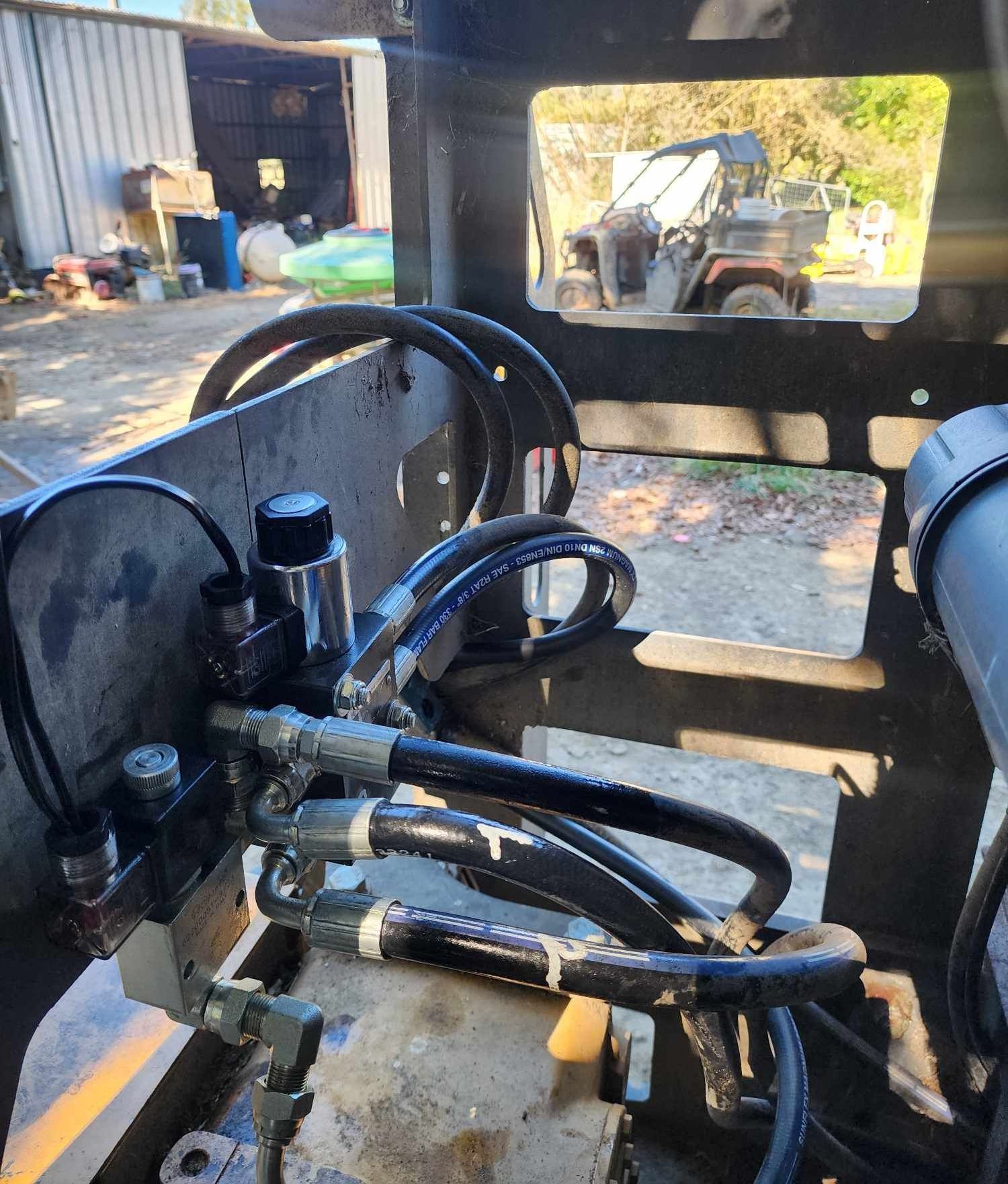 A close up of a hydraulic system on a feedout mixer.