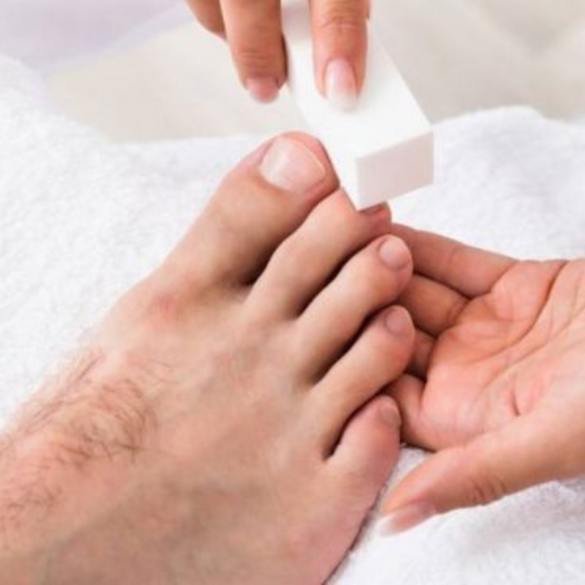 Los dedos de los pies se limpian con una piedra pómez blanca a mano, sobre una toalla.