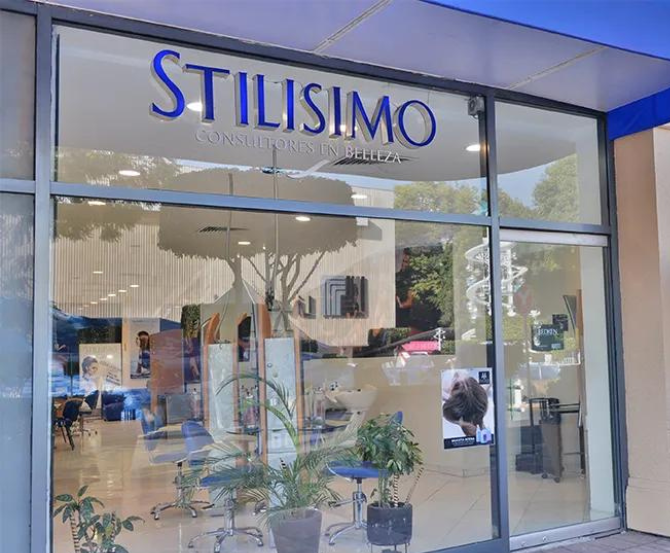 Fachada de la boutique Stilissimo con ventanas de cristal y un letrero azul sobre la entrada.