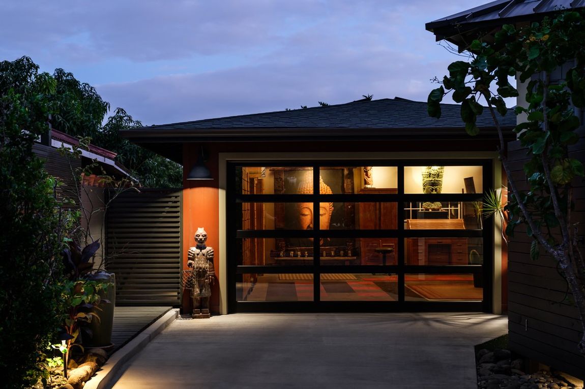 A house with a large garage door is lit up at night