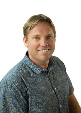 A man in a blue shirt is smiling for the camera.