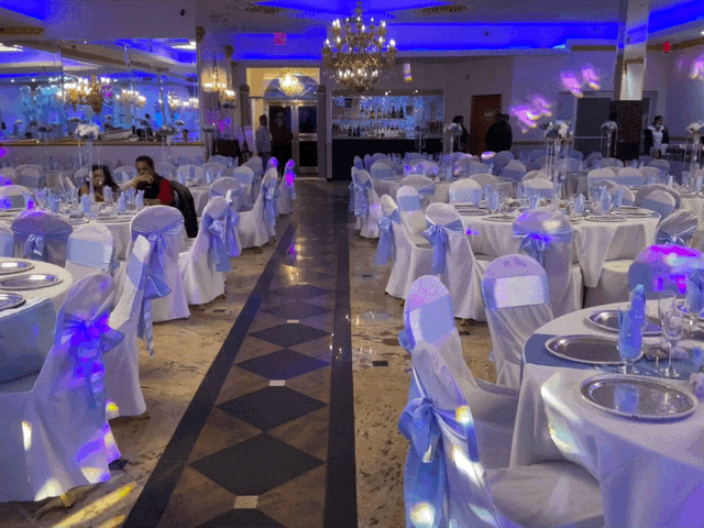 A large room with tables and chairs set up for a wedding reception.