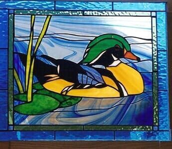 A stained glass painting of a duck in the water