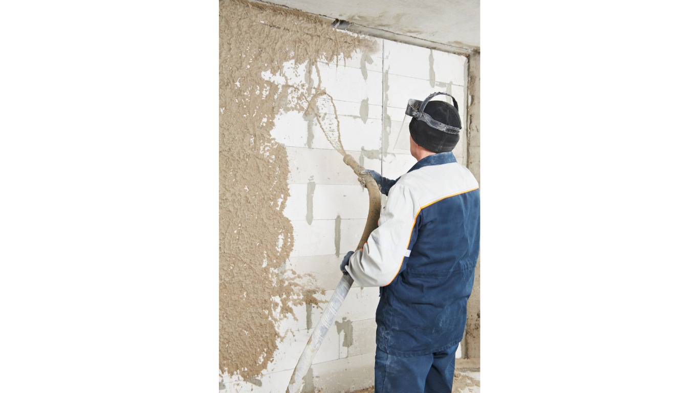 contractor using stucco spray gun on wall repair