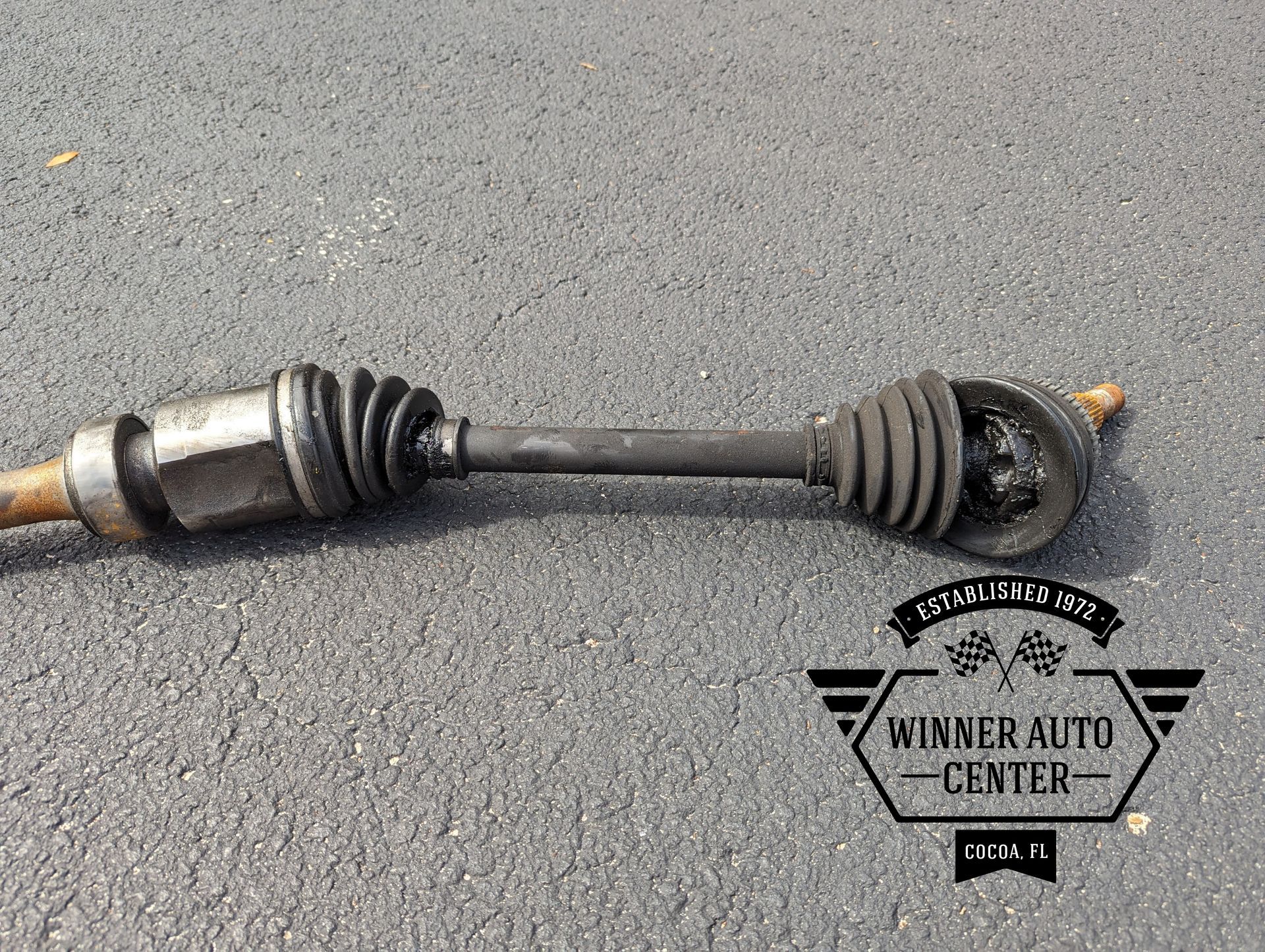 A disassembled car axle on asphalt | Winner Auto Center