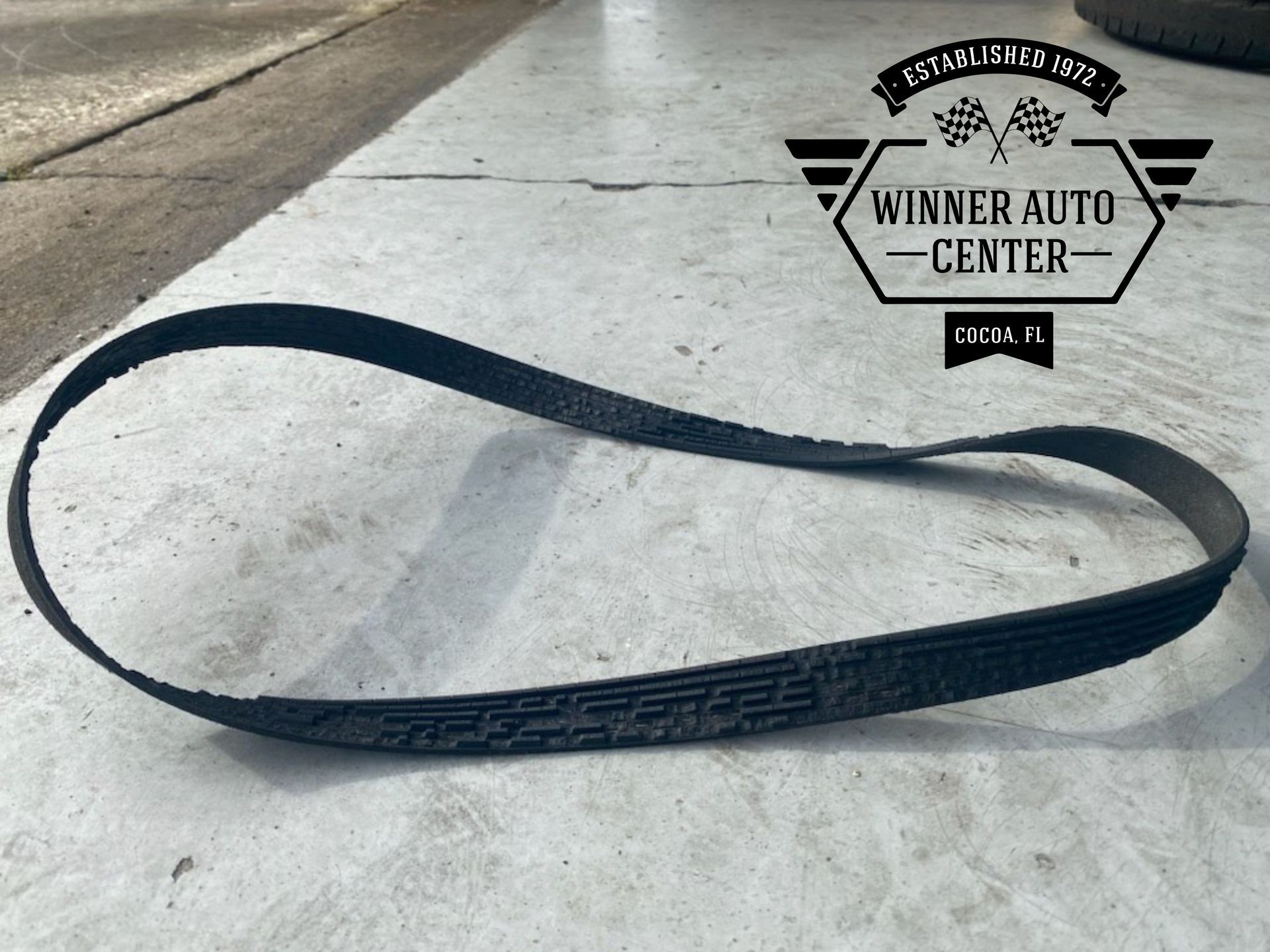 A serpentine belt on a concrete surface | Winner Auto Center