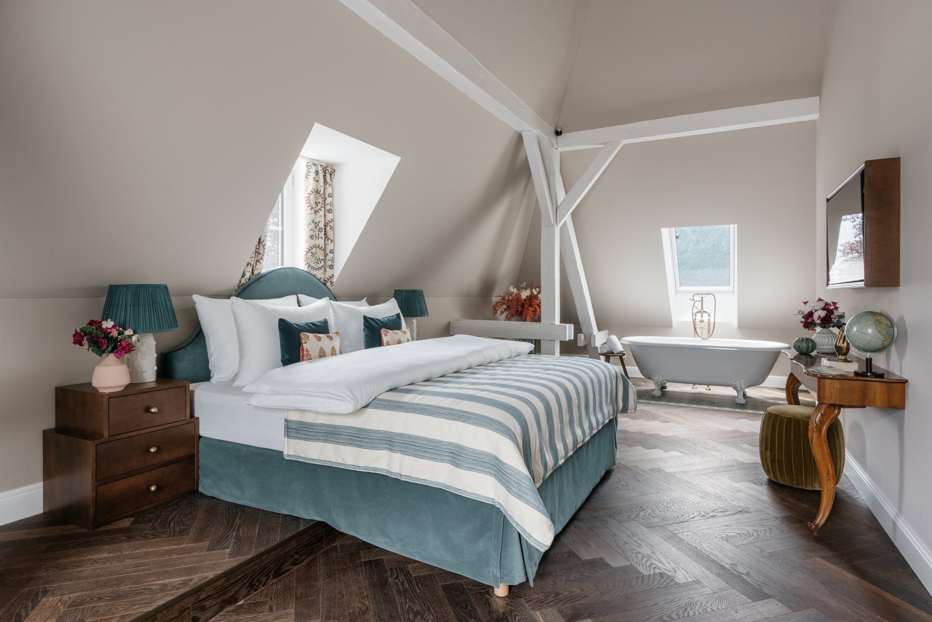 großes helles Schlafzimmer mit Bett und freistehender Badewanne