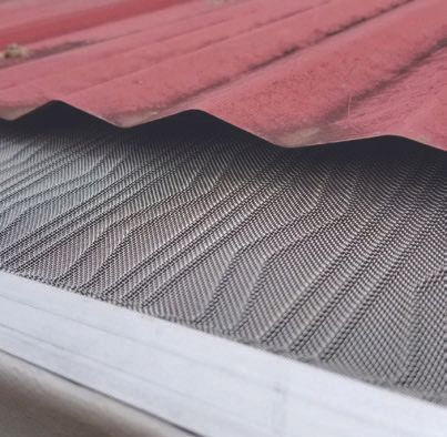 Red roof over a gray mesh gutter guard on a house edge