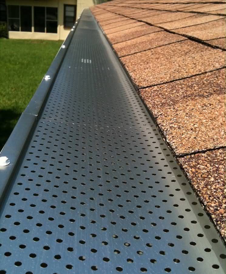 Close-up of a window sill with textured gray mesh and a white trim edge