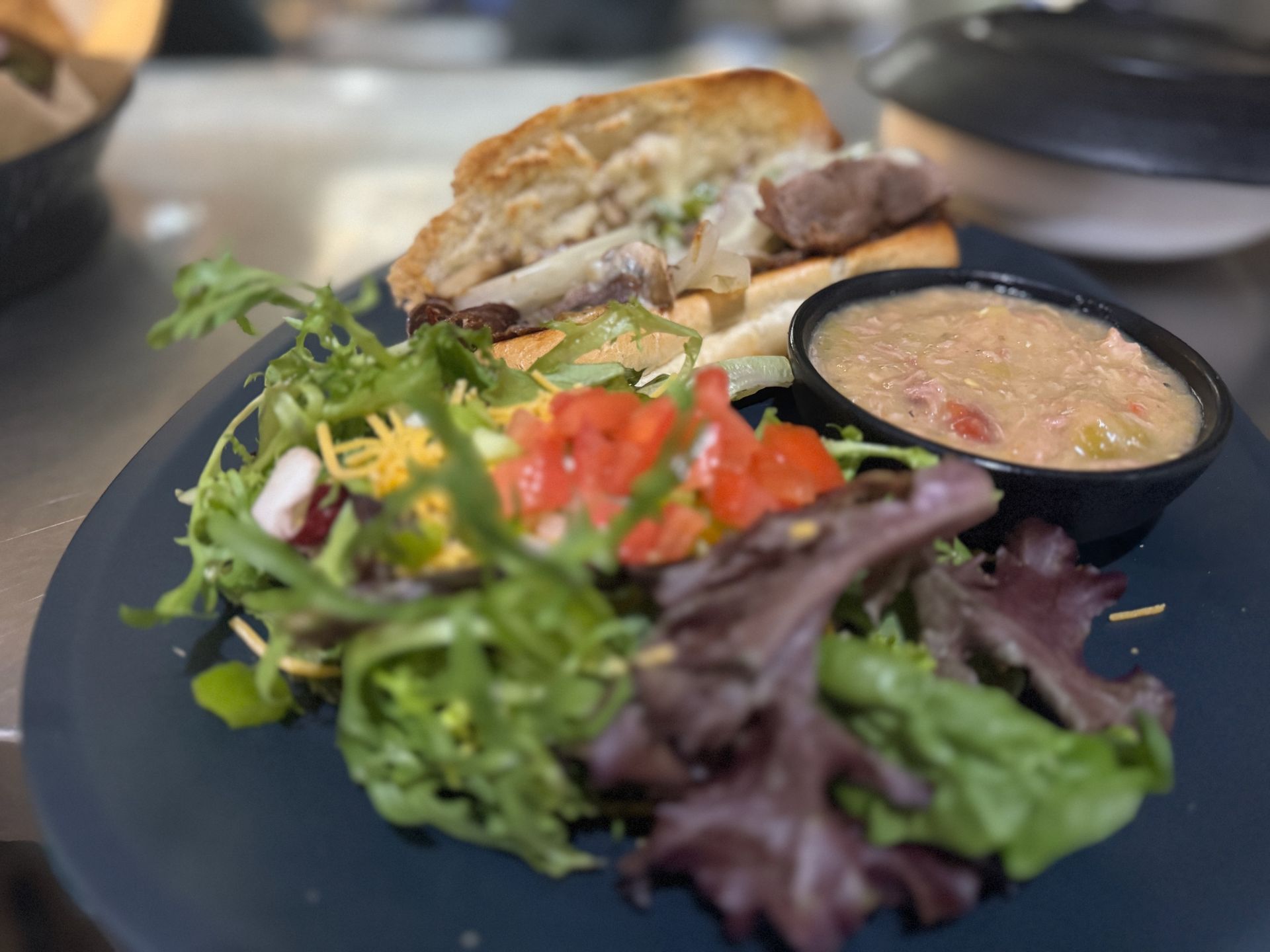 A plate of food with a sandwich and a salad on it.
