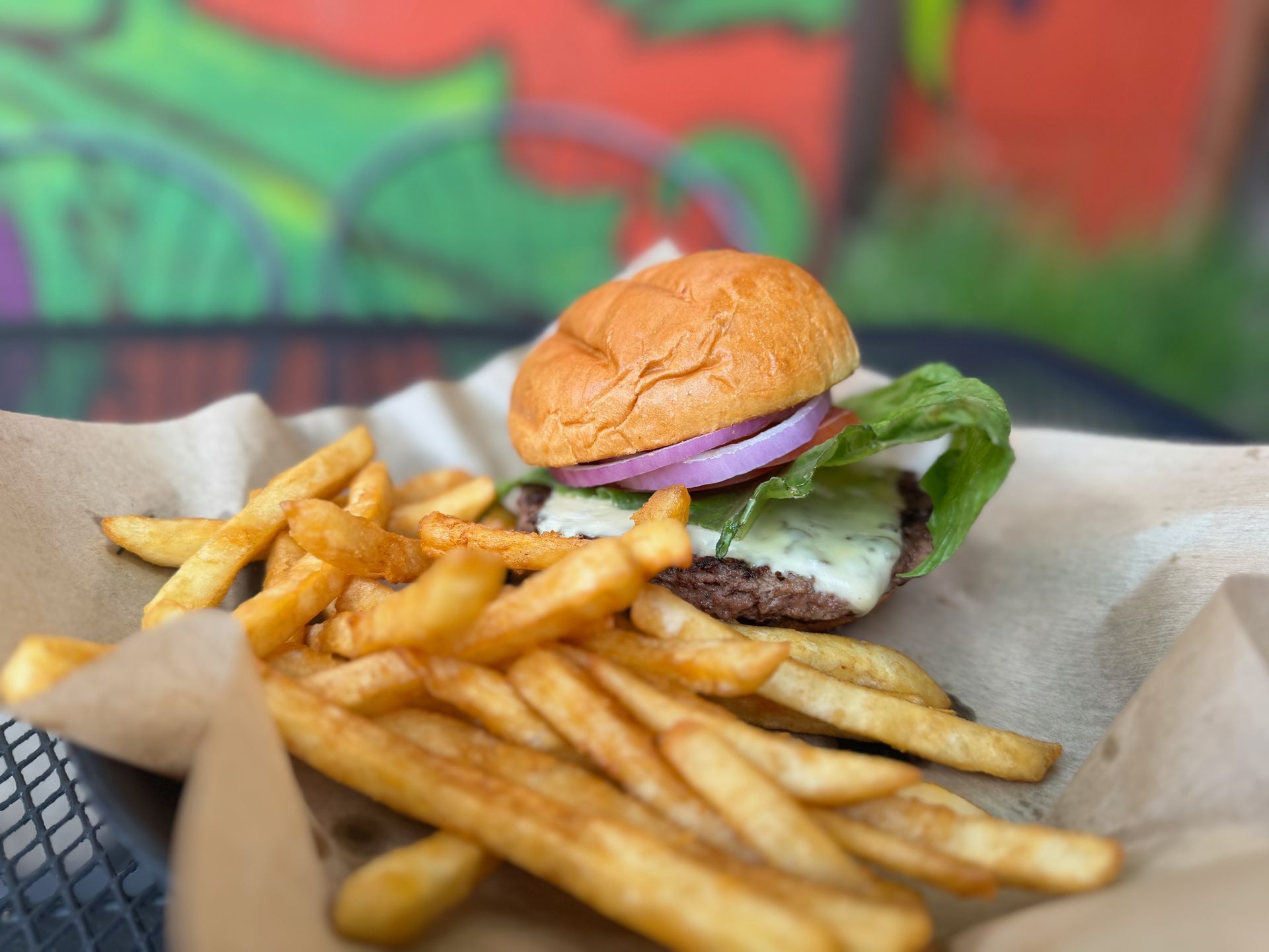 A hamburger and french fries in a basket on a table.