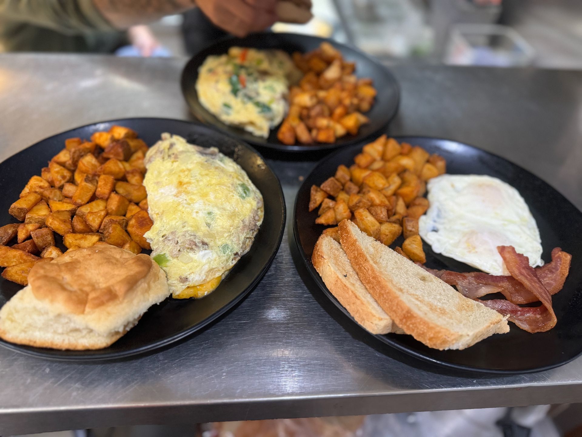 Three plates of food are sitting on a table.