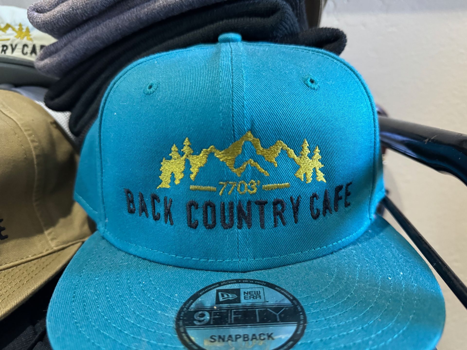 A blue hat that says back country cafe on it