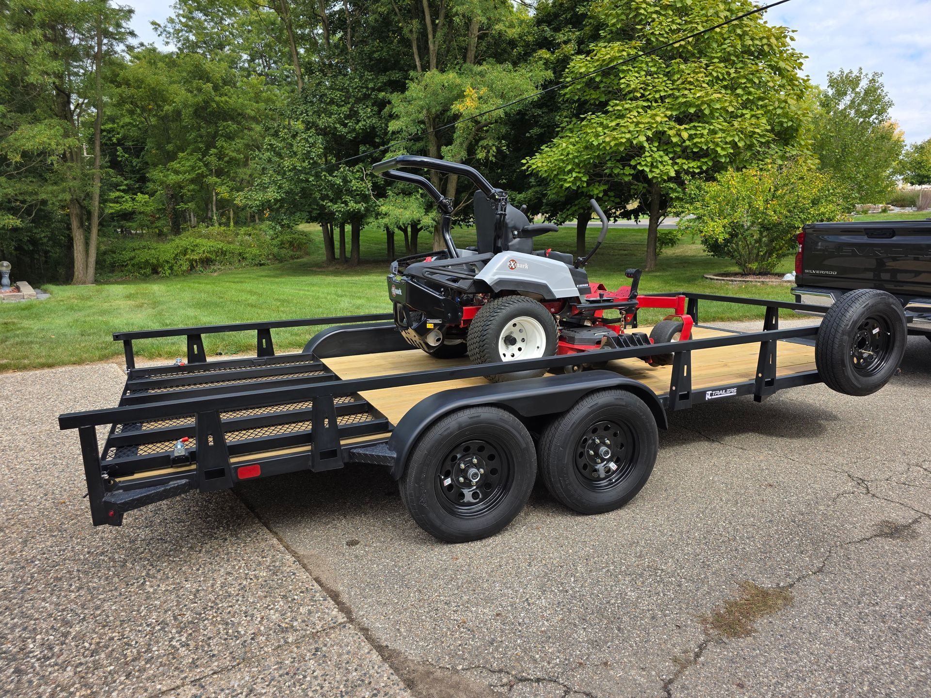 Tandem steel utility trailer with rear ramp in lay down position