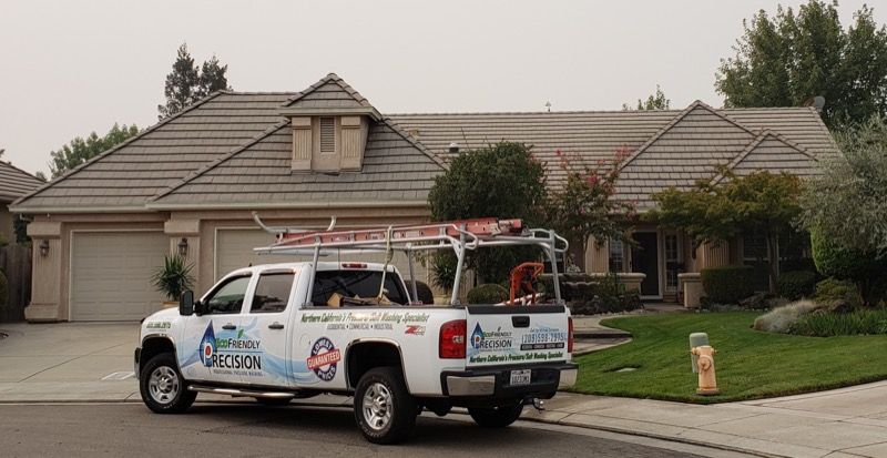 White utility pickup truck parked in front of a suburban house on a quiet street
