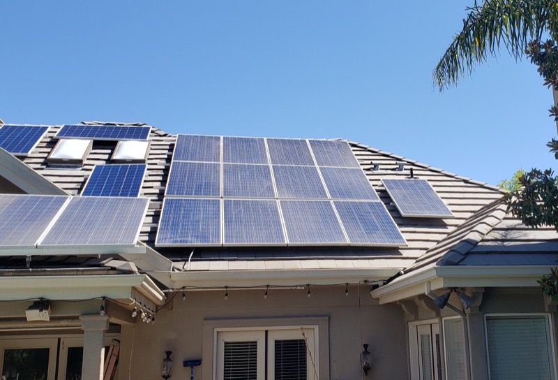 House roof with large solar panels under a clear blue sky