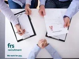 Hands reviewing a resume during a job interview, with a logo for